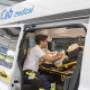 Mitarbeiter easyCab medical betreut Patienten, der auf Stryker liegt im Krankentransportfahrzeug