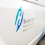 Seitliche Ansicht eines weissen Firmenfahrzeugs mit dem gut sichtbaren Logo der U. Hauenstein Heizung Lüftung Sanitär AG. Auf der Fahrzeugseite steht der Firmenname zusammen mit den Bereichen Heizung, Lüftung und Sanitär sowie dem Standort Steffisburg