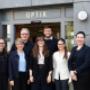Das Team von Kühnis Brillen steht freundlich lächelnd vor dem Eingangsbereich des Geschäfts.