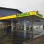 AGROLA Tankstelle in Zweisimmen, Bern, mit TopShop, regnerische Aufnahme, Vorplatz - nass, Tankstelle angeschlossen an blauem Gebäude