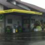 AGROLA Tankstelle in Neuenegg überdacht; regnerische Aufnahme mit nasser Strasse; zwei Tanksäulen mit Zahlterminal