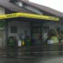 AGROLA Tankstelle in Neuenegg überdacht; regnerische Aufnahme mit nasser Strasse; zwei Tanksäulen mit Zahlterminal
