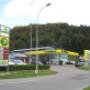 AGROLA Tankstelle in Wolhusen mit TopShop und Landi Laden. Einfahrt zur Tankstelle, links daneben Schild mit Landi Logo, AGROLA Diskus Logo und digitale Preisanzeige Schild