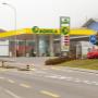 AGROLA Tankstelle in Triengen mit TopShop; im Vordergrund Strasse und Fussgängerstreifen. Grosse Überdachung und Totem mit Landi Logo, AGROLA Diskus und digitaler Preisanzeige und TopShop Logo