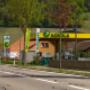 AGROLA Tankstelle in Unterstammheim; im Vordergrund Strasse. Bei Tankstelle Fahne von Landi und Fahne von AGROLA. Totem an Strasse.