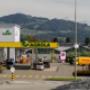 AGROLA Tankstelle in Dürnten mit Landi Laden und TopShop. Grosse Einfahrt mit Fussgängerstreifen. Rechts Totem mit Landi Logo, AGROLA Diskus und digitaler Preisanzeige