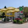 AGROLA Tankstelle in Heiden; Glasdach geschwungen über Tankstelle; im Vordergrund grosses Totem mit digitaler Preisanzeige