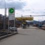 AGROLA Tankstelle in Herisau. Rechts Bahngleise gelegen. Tankstelle mit gelbem Gerüst. Im Vordergrund Totem mit AGROLA Diskus und Preisanzeigeschildern