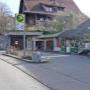 AGROLA Tankstelle in Maschwanden; zwei Tanksäulen zwischen Gebäuden gelegen. Links Pfeiler mit AGROLA Logo und Preisschildern