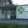 AGROLA Tankstelle in Pfäffikon, Schwyz. Grosses AGROLA Logo an Fassade, rechts daneben digitale Preisanzeige. Eine Tanksäule und ein Zahlterminal.