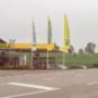 AGROLA Tankstelle in Ettiswil mit TopShop. Strasse im Vordergrund . Mittig drei grosse Fahnen - Landi, TopShop und AGROLA Fahnen. Dahinter AGROLA und TopShop.