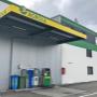 AGROLA Tankstelle in Oberbuchsiten; Eine Tanksäule mit Zahlterminal; daneben auch AdBlue Tanksäule; grüner Mülleimer und PET Behälter; überdacht; rechts weiss-grüne Hausfassade mit AGROLA Logo