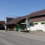 AGROLA Tankstelle in Waldkirch; bei Landwirtschaftsgebäude gelegen. Im Vordergrund Strasse und Totem mit Preisanzeige AGROLA Diskus und Landi Logo