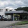 AGROLA Tankstelle in Gümmenen bei Mercedes-Benz; links im Bild Totem mit AGROLA Logo und Preisschildern darunter Selecta Automat