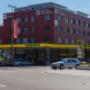 AGROL Tankstelle und LAVEBA Shop in Lachen bei Hotel im Kreisel Lachen. Tankstelle in Gebäude mit roter Fassade. Rechts im Bild Kreisel.