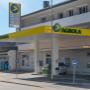 AGROLA Tankstelle in Hausen am Albis. Überdacht mit einer Tanksäule. Dach an Gebäudewand angebracht. Schild mit Pfeil zur Einfahrtsanzeige