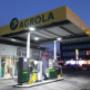 AGROLA Tankstelle in Hinwil mit Shop; Abendaufnahme; rechts Gebäude mit beleuchteten Fenstern; starke Flutlichter an Decke von Tankstelle