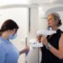 Zahnärztin behandelt Patientin stehend bei Smile Clinix