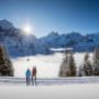 Winterwanderung auf verschneiten Winterwanderwegen rund um Grindelwald. Die Wanderer geniessen den sonnigen Tag und imposanten Ausblick auf den Eiger.