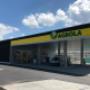AGROLA Tankstelle in Konolfingen; überdacht mit TopShop; Vorplatz im Vordergrund, links Totem-Schild mit AGROLA Logo, digitaler Preisanzeige von Treibstoff, AdBlue, TopShop und selfwash logo