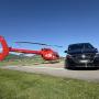 A seamless luxury transfer experience by FunFlights Helicopter-Tours in partnership with Aratours: a sleek helicopter and a premium Mercedes limousine are positioned side by side in the departure zone at Bern Airport. A VIP guest has just arrived and is t