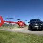 A seamless luxury transfer experience by FunFlights Helicopter-Tours in partnership with Aratours: a sleek helicopter and a premium Mercedes limousine are positioned side by side in the departure zone at Bern Airport. A VIP guest has just arrived and is t