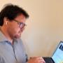 Technicien informatique Cliczen concentré sur son ordinateur portable à Genève