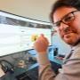 Technicien informatique Cliczen satisfait devant son écran avec pouce levé à Genève