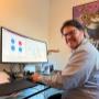 Consultant informatique Cliczen à son bureau à Genève avec écran courbé Dell et tableau de bord