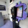 Vue complète du point Bitcoin ATM avec signalétique visible depuis la rue principale.