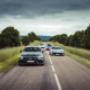 Sports cars driving on a scenic European country road during a curated luxury driving tour across Europe.