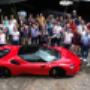 Group of international guests celebrating during a luxury supercar driving experience in Europe with a Ferrari SF90.