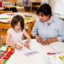 Child practising handwriting with teacher support at ELABasel bilingual preschool in Basel